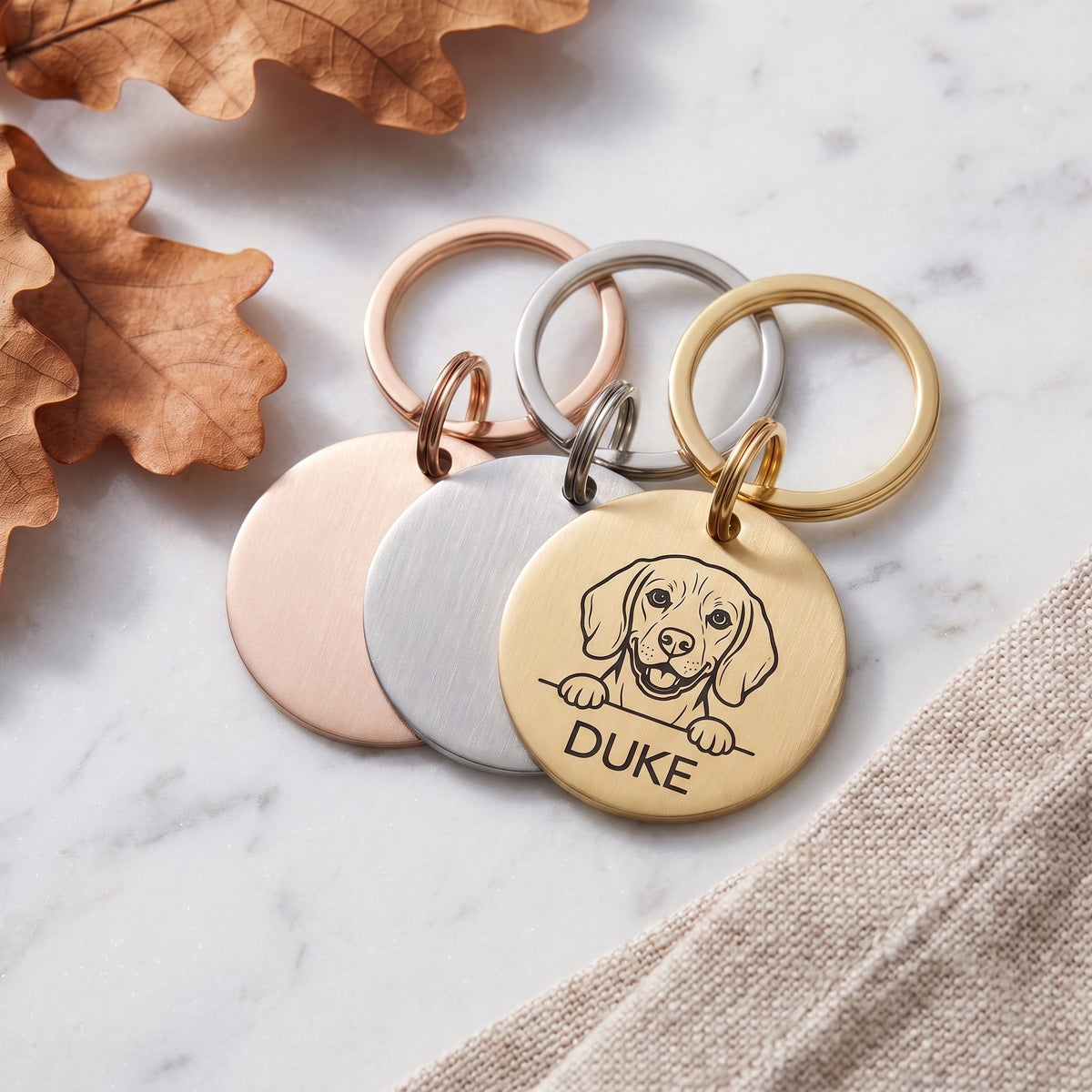 Personalised Beagle dog tags in gold, silver and rose gold, fanned to show the three colours