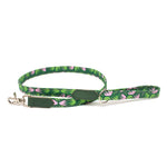 Green dog leash with pink floral pattern on a white background
