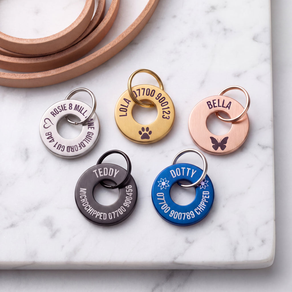 Washer dog tags in gold, silver, rose gold, black and blue showing how much engraving fits on each
