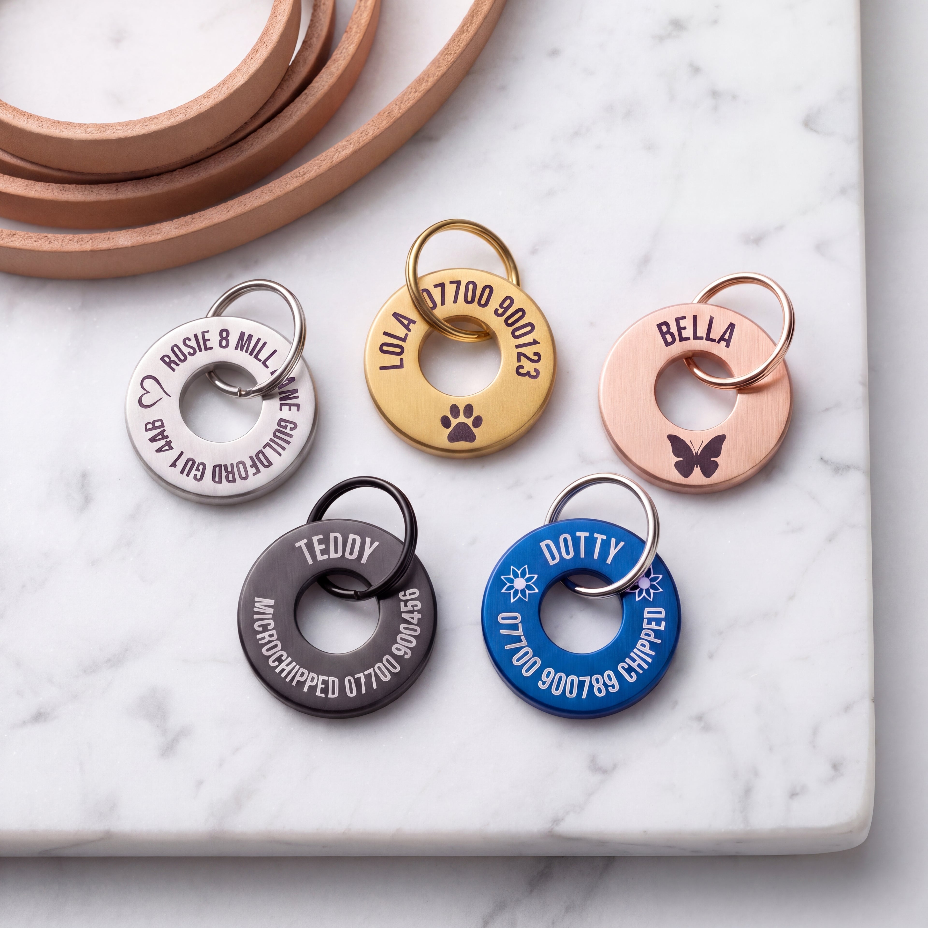 Washer dog tags in gold, silver, rose gold, black and blue showing how much engraving fits on each