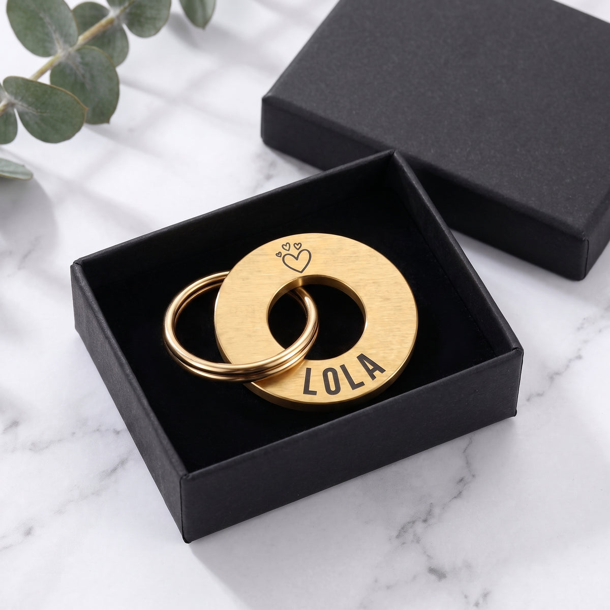 Gold washer dog tag in its matte black gift box